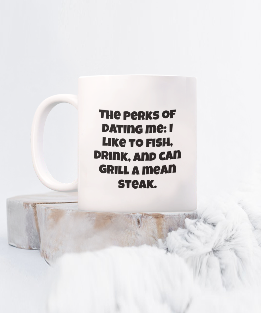 The perks of dating me: I like to fish, drink, and can grill a mean steak. 11oz coffee mug, white, funny