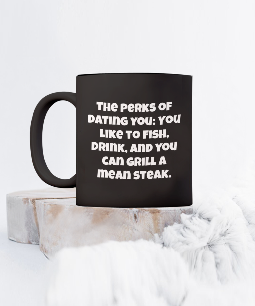 The perks of dating you: You like to fish, drink, and you can grill a mean steak. 11oz coffee mug, black, funny